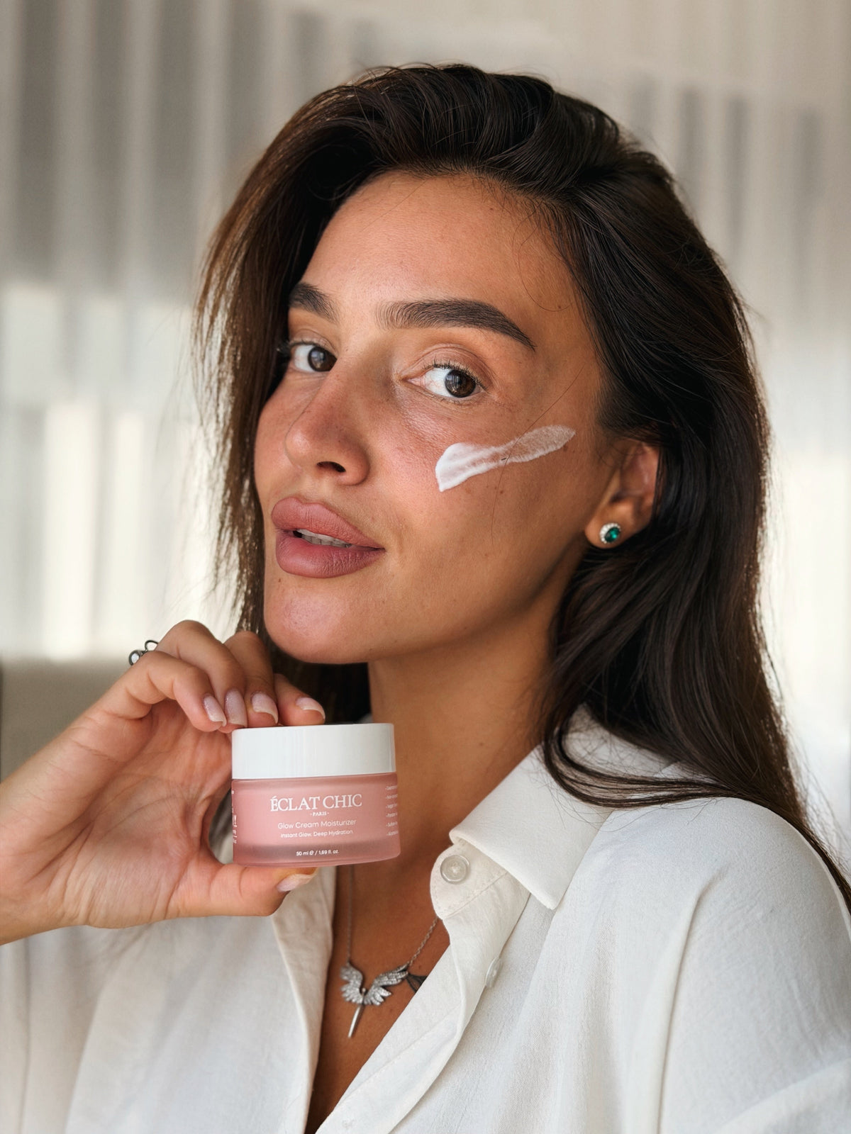 Yanağına Glow Cream Moisturizer süren kadın