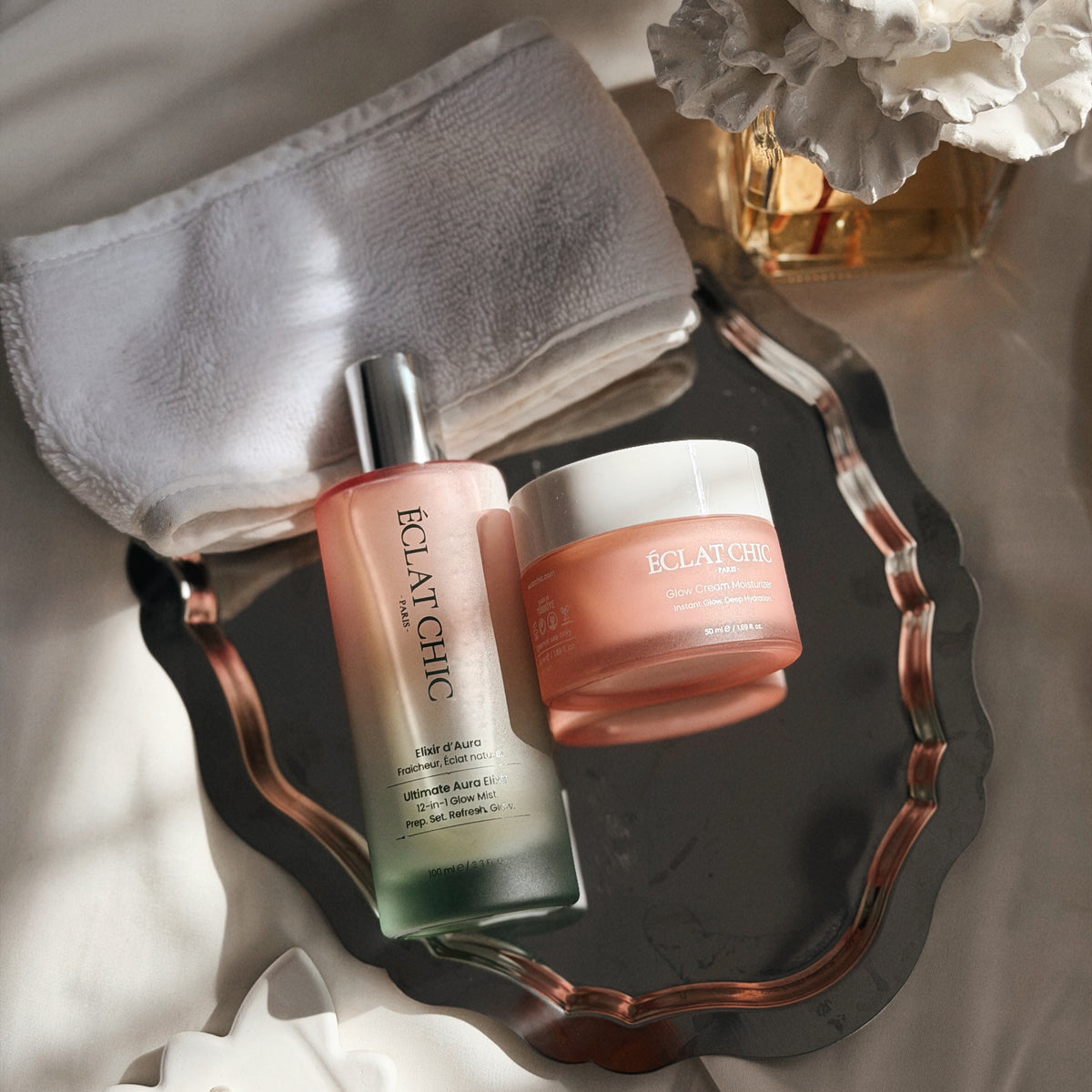 Ultimate Aura Elixir ve Glow Cream, inciler ve keten havlu arasında