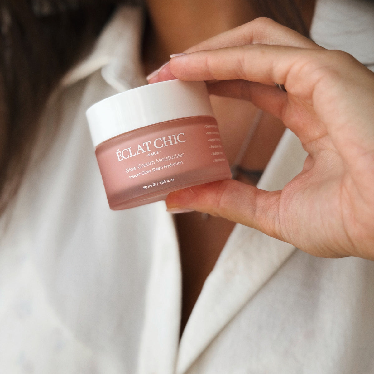Elinde Glow Cream Moisturizer kavanozu tutan kadın